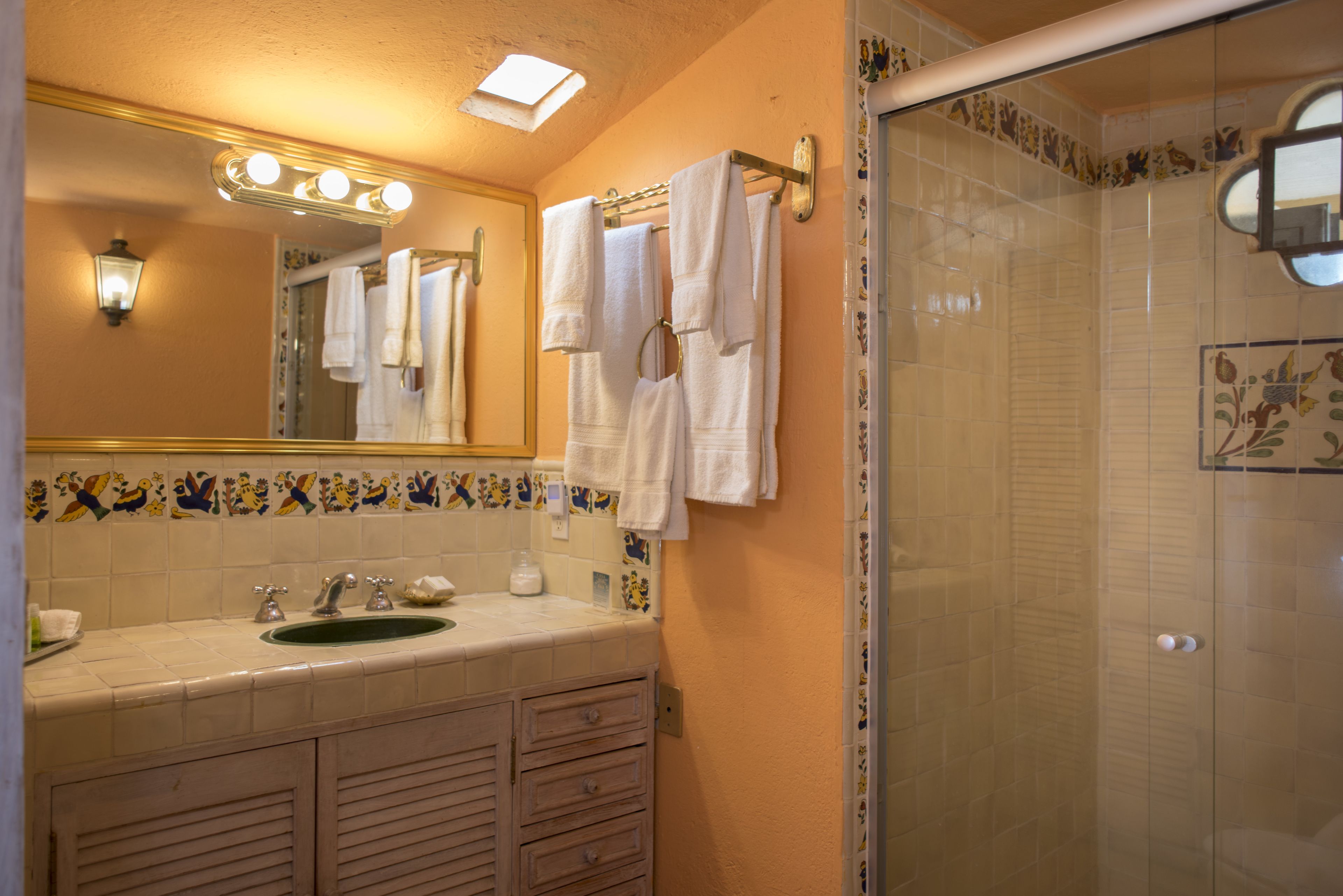 Une salle de bain avec un lavabo, un miroir et une douche.