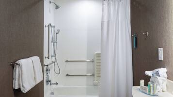 A modern bathroom with a bathtub, shower, and toilet.