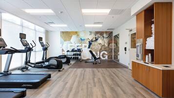 A gym with treadmills, elliptical machines, and weight equipment.