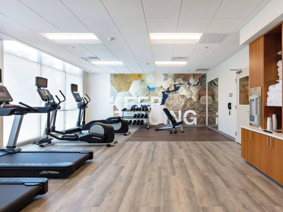 A gym with treadmills, elliptical machines, and weight equipment.