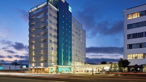 Een hotel met meerdere verdiepingen, met een opvallend bord voor het AC Hotel Marriott.