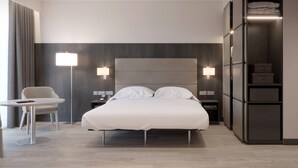 Een moderne hotelkamer met een groot bed, nachtkastjes, een bureau en een kledingkast.