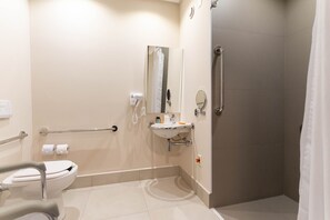Un baño moderno con inodoro, lavamanos y ducha.