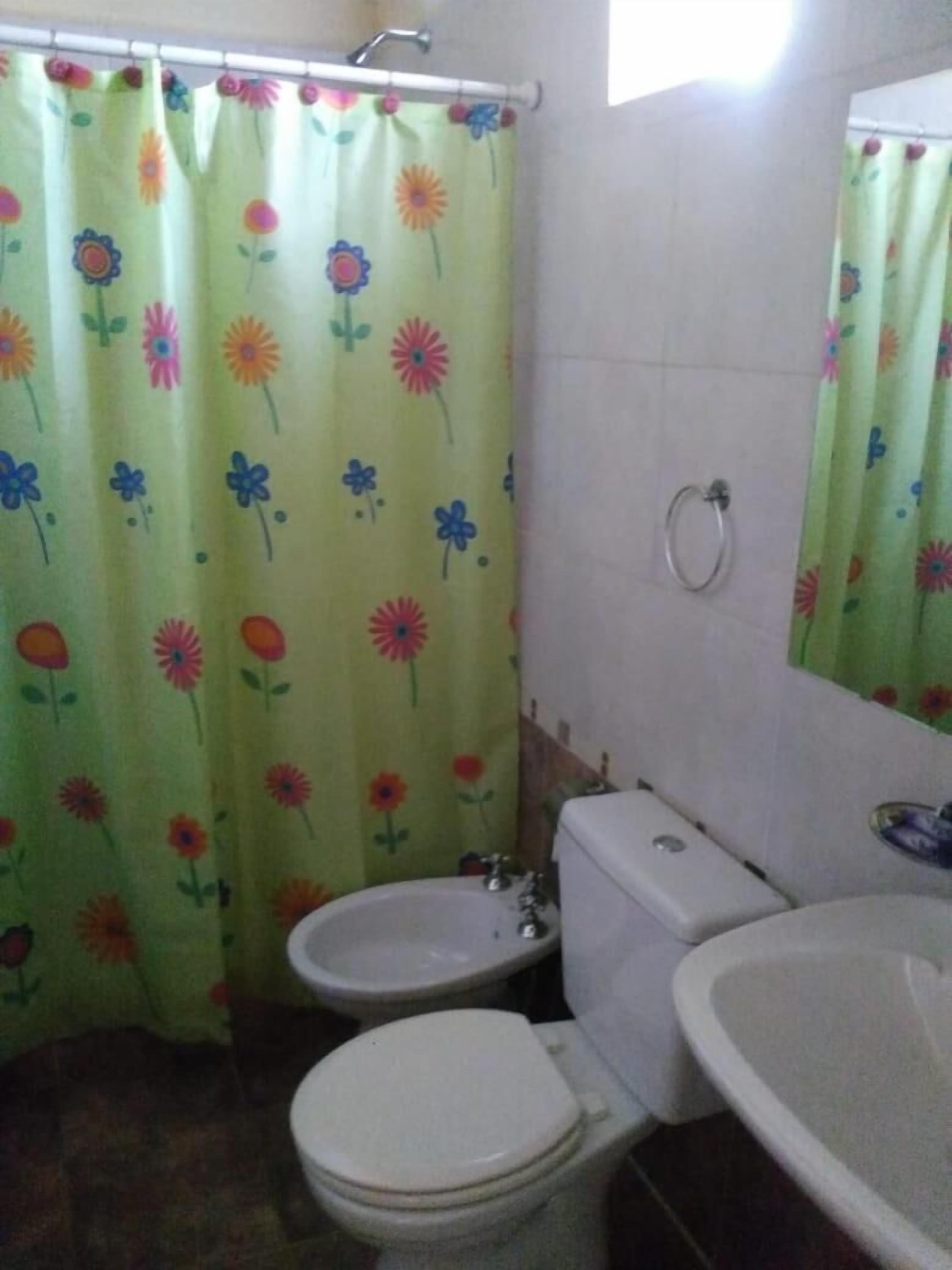 Un baño con inodoro, bidé y lavamanos.