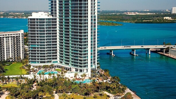 A high-rise hotel with multiple floors, a pool area, and a beach view. - One Bal Harbour Hotel and Resort, Deluxe 2 bedroom private unit @ the Ritz (Bal Harbour)