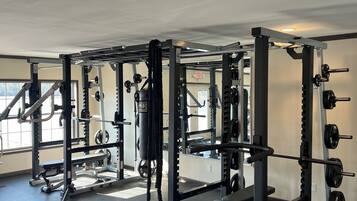 A gym with various weightlifting equipment, including squat racks and benches.