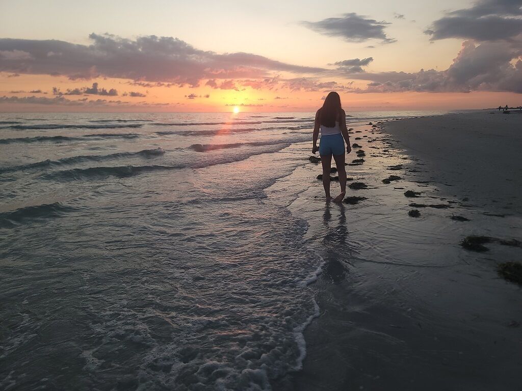 A beach scene with waves at sunset.
