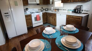 A kitchen with wooden cabinets, a white refrigerator, a microwave, and a coffee maker. -  Wonderful 2/1 in Bouldin area.Walk to food trailers, Zilker and Barton Springs! (Austin)
