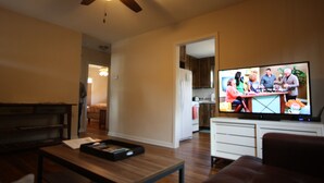 A living room with a television, wooden coffee table, and a ceiling fan. -  Wonderful 2/1 in Bouldin area.Walk to food trailers, Zilker and Barton Springs! (Austin)