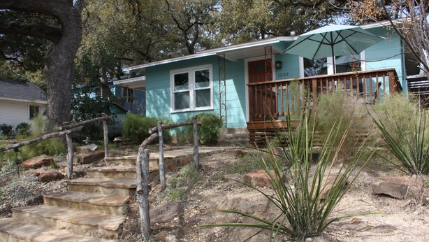 A house with a porch, stone steps, and a wooden railing. -  Wonderful 2/1 in Bouldin area.Walk to food trailers, Zilker and Barton Springs! (Austin)