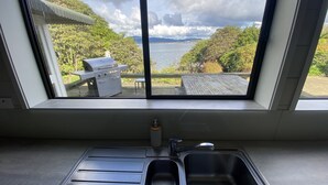 Cocina con vista a un muelle, una parrilla y follaje.