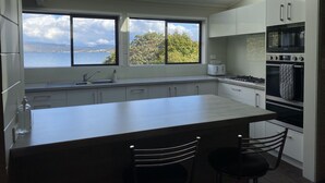 Una cocina moderna con una isla grande, vistas al mar y un tragaluz.