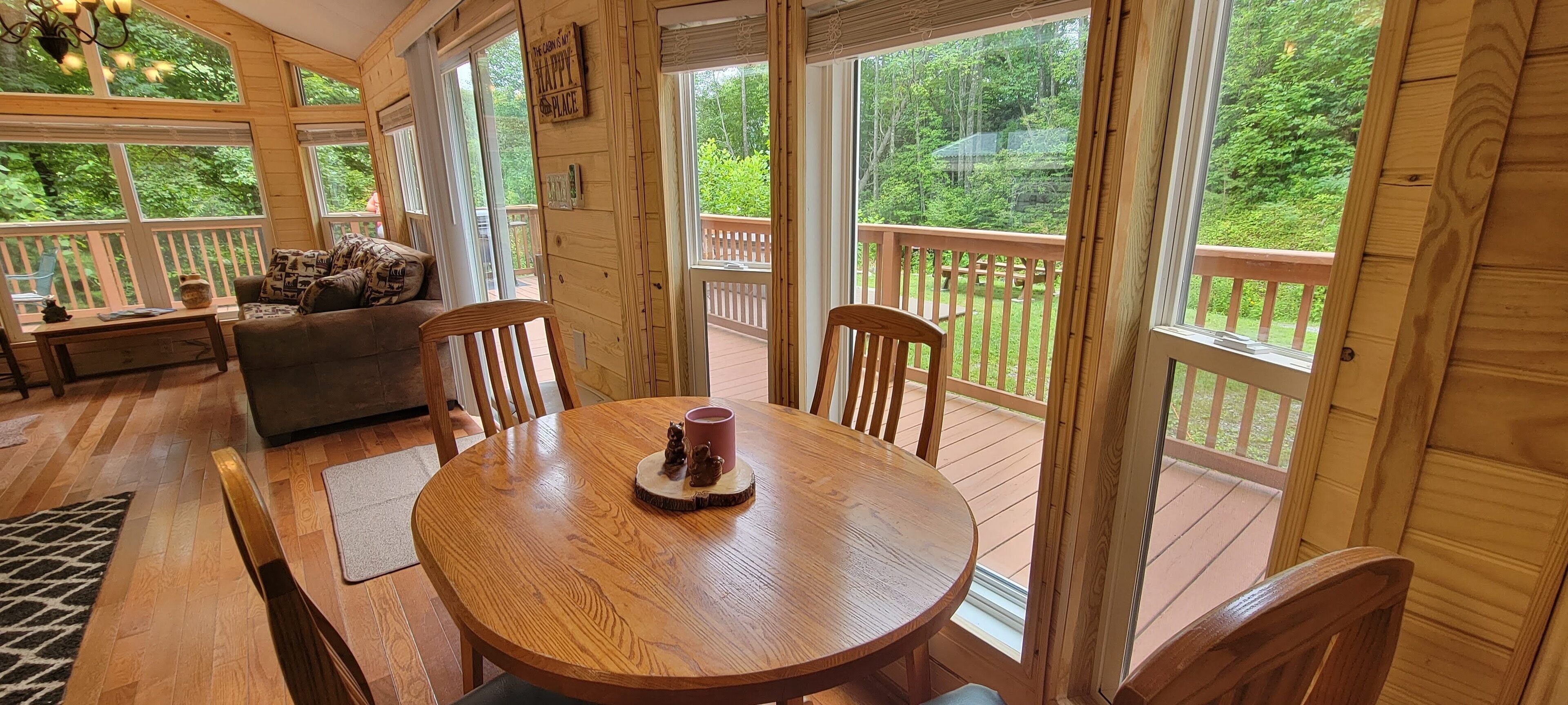 A wooden deck with a dining table and chairs, a sofa, and a bench.