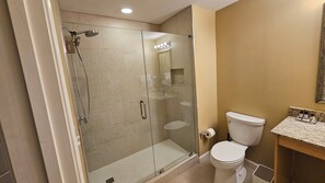 A modern bathroom with a glass-enclosed shower, a toilet, and a vanity with a marble countertop. - Oceanfront Luxury 6th Floor Splash Resort: 2BR/2BA King Unit, Free Beach Service (Panama City Beach)