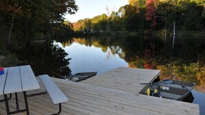 A wooden dock with a picnic table and a small boat. - Relax & Recharge!Swim/fish/swim/boat in Autumn Lk, SalmonRiverMinsAway-Cottage3 (Altmar)