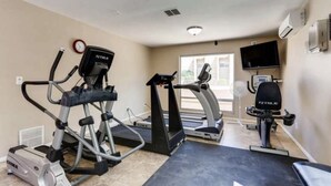 A fitness room with treadmills, an elliptical, and a stationary bike, equipped with a TV and a fan. - Bright and Peaceful condo 2 bedrooms  2 bath comfortable clean Great location! (Phoenix)