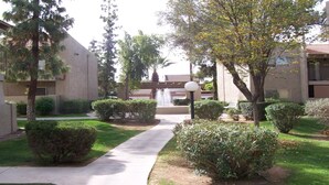 A courtyard with a central fountain, surrounded by neatly trimmed bushes and trees. - Bright and Peaceful condo 2 bedrooms  2 bath comfortable clean Great location! (Phoenix)