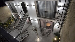 Een gebouw met meerdere verdiepingen, balkons, trappen en buitenplaatsen.