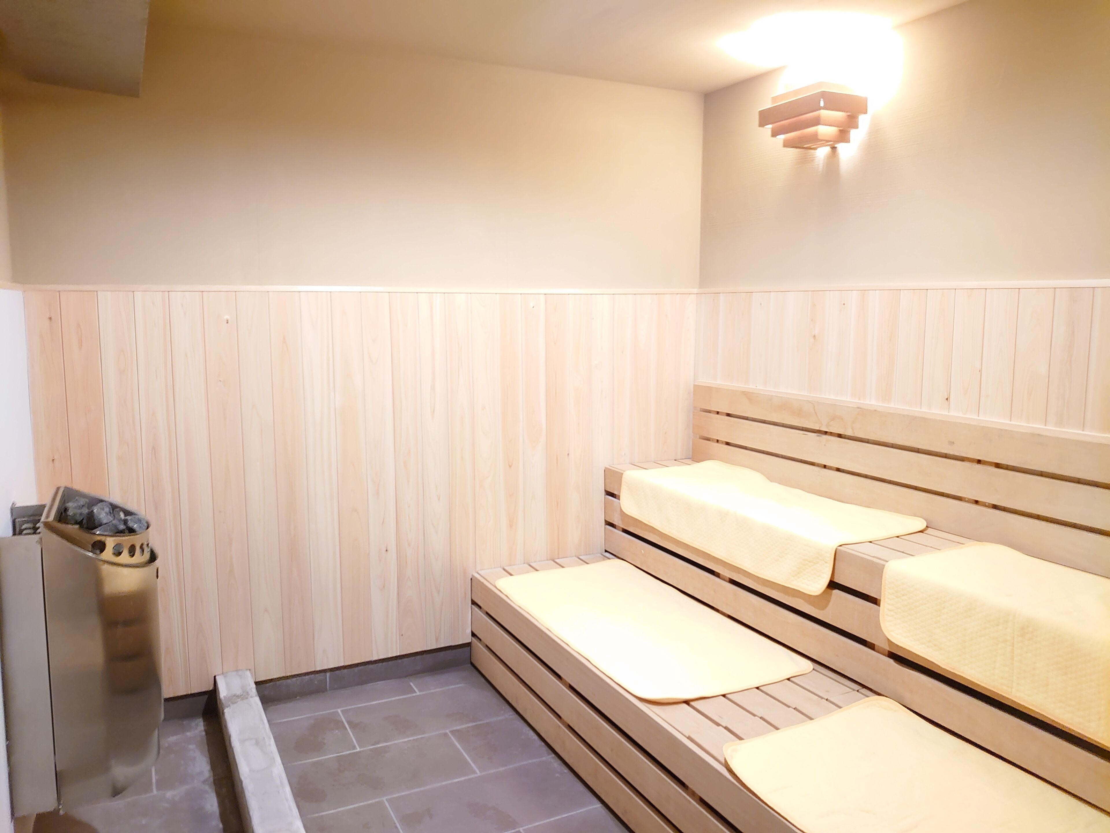 Un sauna avec des bancs en bois et un chauffage intégré dans un des bancs.