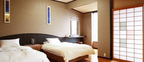 A hotel room with two beds, a large window, and a traditional sliding door.
