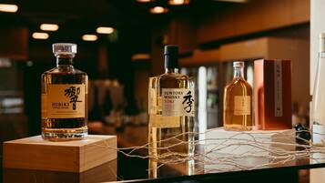 Tres botellas de whisky japonés exhibidas junto con cajas de madera y un adorno de cuerda.