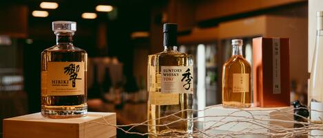 Three bottles of Japanese whisky on display with wooden boxes and a decorative string.