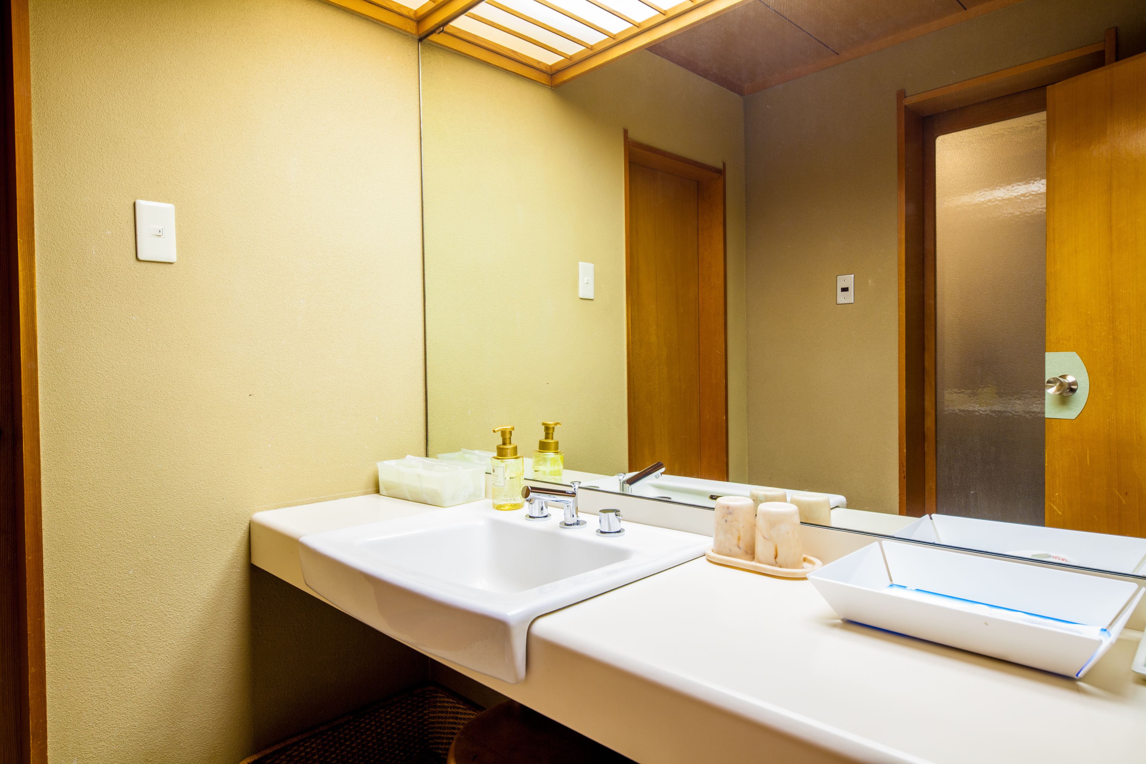 A hotel bathroom with two sinks, a mirror, and toiletries.