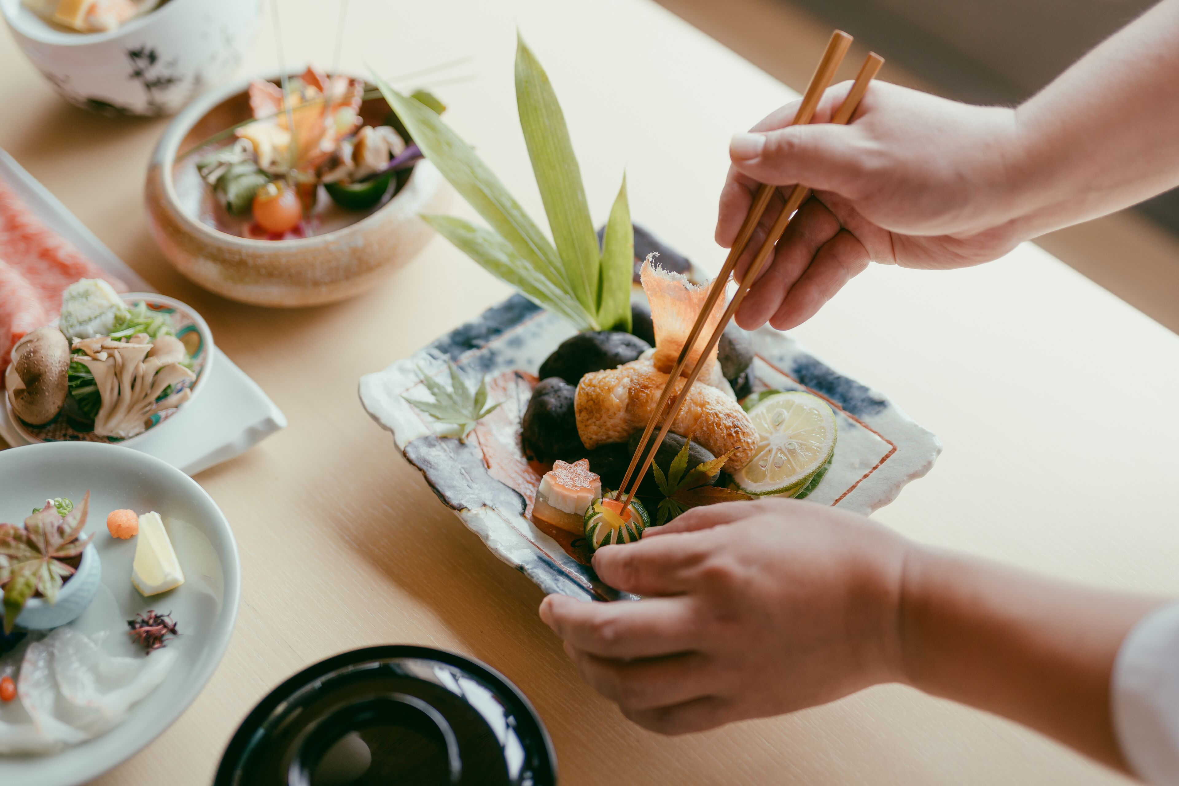 Una mesa de comedor con varios platos, incluyendo sushi y un tazón de sopa.