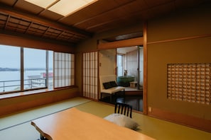 A traditional Japanese room with tatami flooring, a low table, and sliding doors.