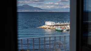 A coastal view with a dock, boats, and a distant mountain.