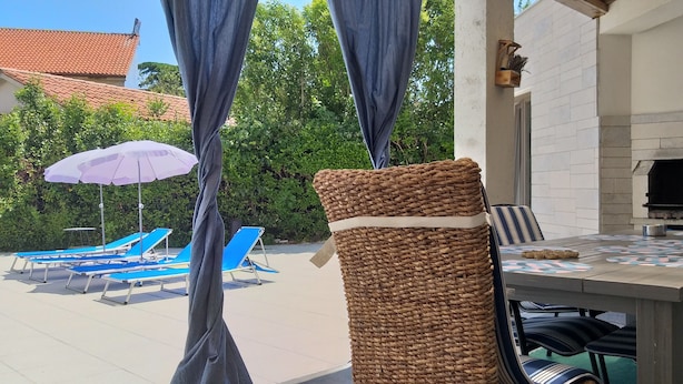 Un patio con mesa, sillas y una cesta de mimbre.