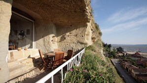 A stone building with a balcony overlooking a coastal area. - Unusual holiday in a troglodyte house in Saint-Chamas. (Saint-Chamas)