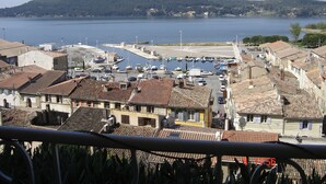 A coastal town with terracotta-roofed buildings, a marina, and a hilly backdrop. - Unusual holiday in a troglodyte house in Saint-Chamas. (Saint-Chamas)