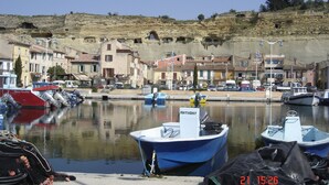 A marina with boats docked, buildings in the background, and a clear sky. - Unusual holiday in a troglodyte house in Saint-Chamas. (Saint-Chamas)