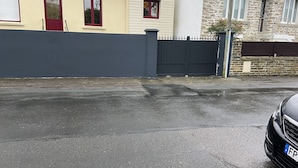 A residential area with a house featuring a red door, a stone wall, and a black fence. - nice quiet house  (Quimper)