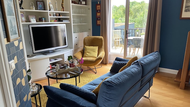 A modern living room with a blue sofa, yellow armchair, and a TV on a white stand. - nice quiet house  (Quimper)