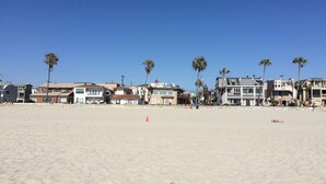 Ein Strand mit Gebäuden im Hintergrund.
