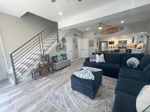 Stylish living space with a staircase, sofa, and kitchen area.