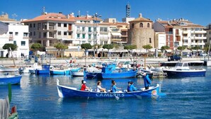 Un port de plaisance où sont amarrés plusieurs bateaux, dont un bleu portant l’inscription « CAMBRILS ».