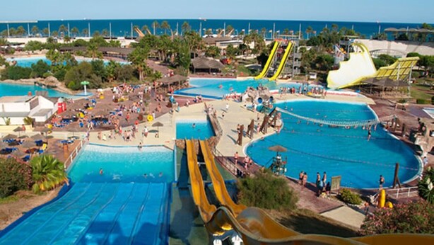 Un parc aquatique doté de plusieurs piscines, de toboggans et d’une zone aménagée en plage.