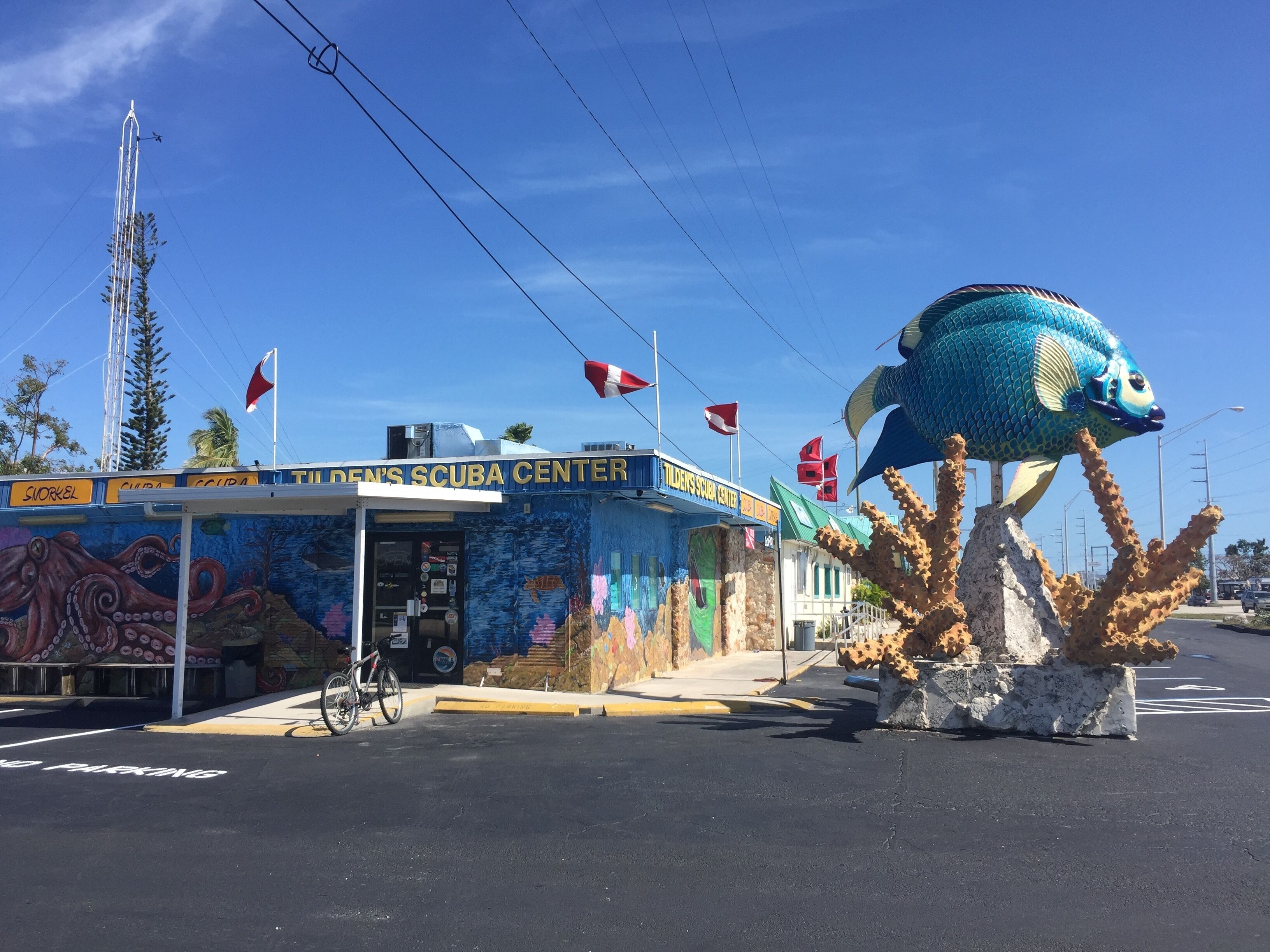 A building with a mural of an octopus and a large fish sculpture.