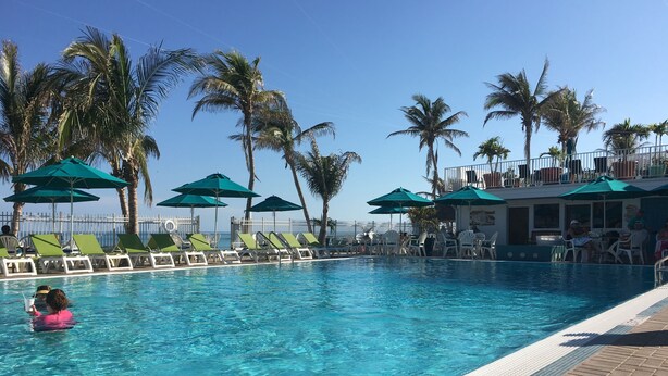 A clear blue pool with lounge chairs and umbrellas, surrounded by palm trees. - September dates w/last minute booking discount, w/Cabana Club Access Included! (Marathon)