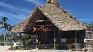A thatched-roof structure with a wooden deck, palm trees, and a sign indicating no parking. - September dates w/last minute booking discount, w/Cabana Club Access Included! (Marathon)