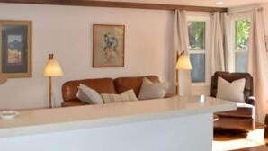 A spacious living area with a sofa set, a coffee table, and two bar stools. - Casita (Prescott)