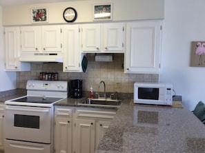 Fully equipped kitchen with stove, coffee maker, and microwave.