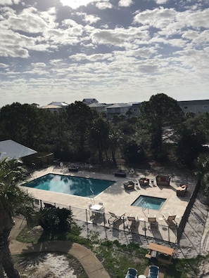 Relax by the rectangular pool surrounded by lounge chairs and a small table.