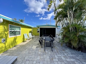 Un bâtiment jaune doté d’un patio couvert, d’un espace extérieur aménagé pour s’asseoir et offrant une vue sur le ciel.