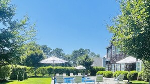 A garden with hydrangea flowers, a swimming pool, and outdoor seating.