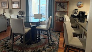 A dining area with a glass-top table, four chairs, a ceiling fan, and a view of the city through large windows. - PICTURE PERFECT!  3 balconies! BC #2406 (Indian Shores)