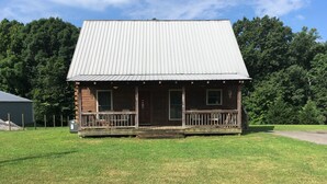 A wooden cabin with a metal roof, a porch, and a small front yard. - Lake Lovers Lodge Dale Hollow Lake Allons TN Near Willow Grove/Lily Dale Resorts (Allons)